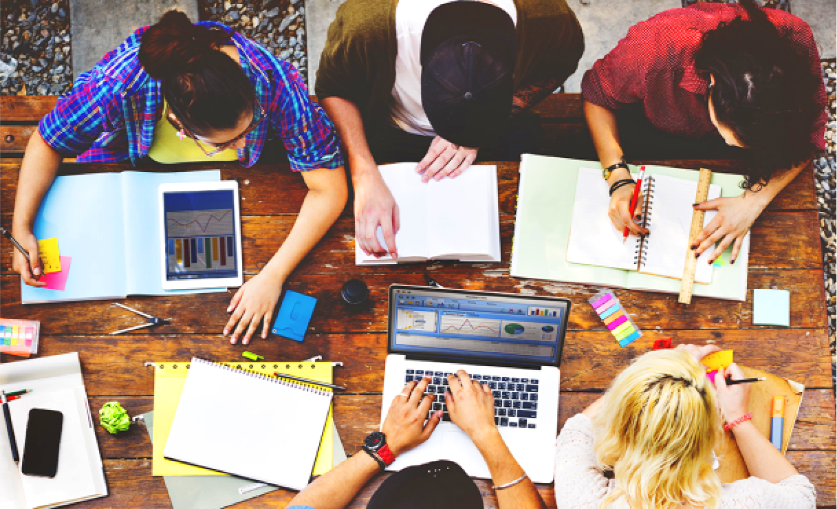 A group of people working with notebooks and laptops